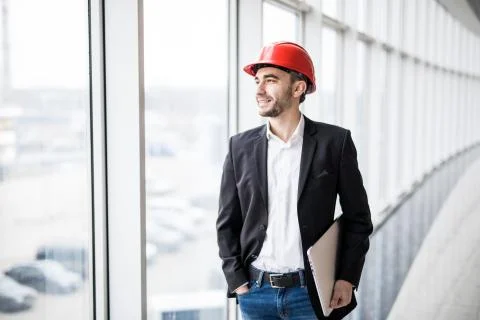 Engineer in hardhat with laptop computer, smiling at camera Stock Photos