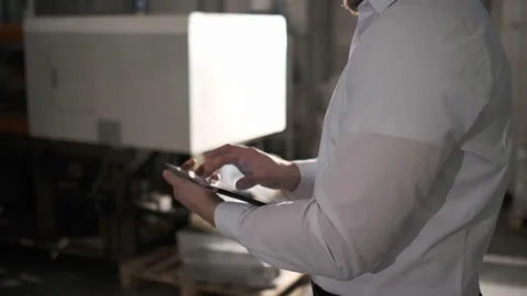 Engineer in hardhat is moving through a heavy industry factory with a tablet Video stock 114503169