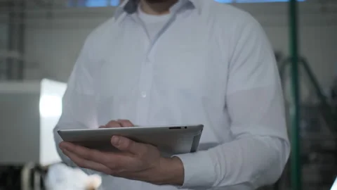 Engineer in hardhat is moving through a heavy industry factory with a tablet Stock Footage 114503385