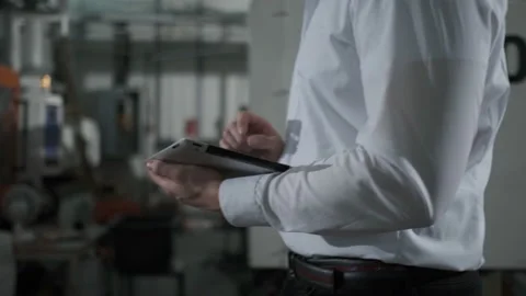 Engineer in hardhat is moving through a heavy industry factory with a tablet Stock Footage 114503531