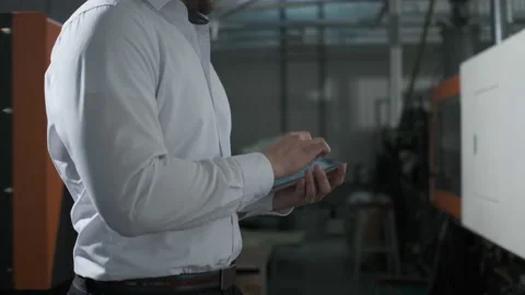 Engineer in hardhat is moving through a heavy industry factory with a tablet Stock Footage 114503576