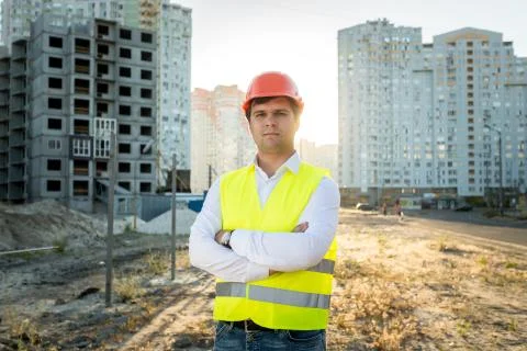 Engineer in hardhat posing against building under construction Stock Photos