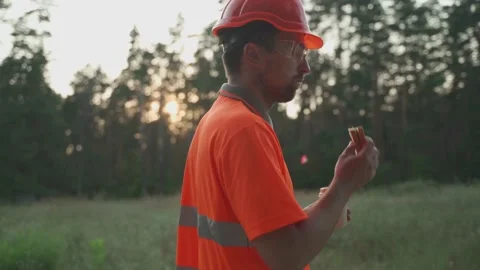 Engineer having lunch near power lines and electricity pylons in the field. An Stock Footage 157826203