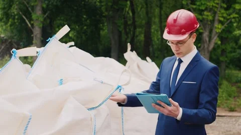 Engineer in helmet and suit holds product audits in large bags Stock Footage 62940385