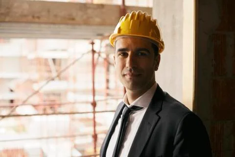 Engineer with helmet in construction site smiling at camera, portrait Stock Photos