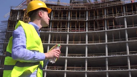 Engineer with helmet hardhat drinking water in lunch break handyman worker site Stock Footage