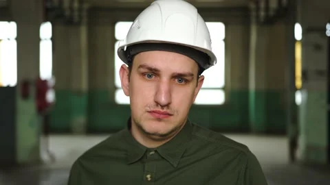 An engineer in a helmet looks at the camera, is very sad, upset, failure at work Stock Footage 152723608