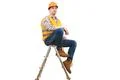 The engineer in helmet sitting on the ladder on the white background Photo
