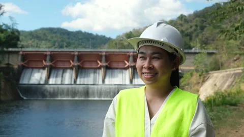 Engineer in helmet standing outside against background of hydroelectric dam Stock Footage 229709011
