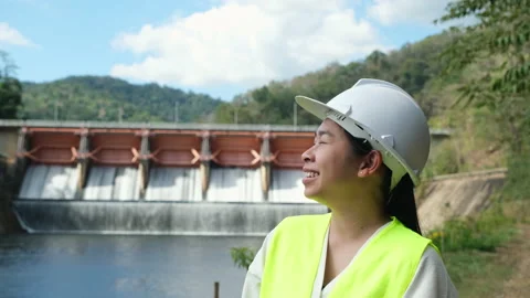 Engineer in helmet standing outside against background of hydroelectric dam Stock Footage 229709168