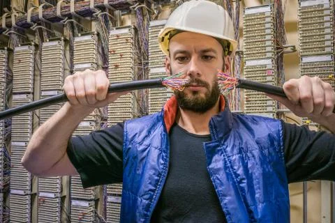 Engineer in a helmet will connect the damaged Internet backbone wire. Worker  Stock Photos