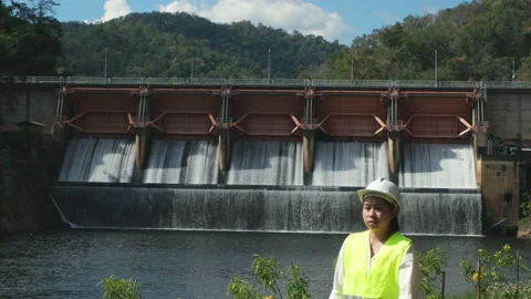 Engineer in helmet working outside against background of hydroelectric dam Stock Footage 229709634