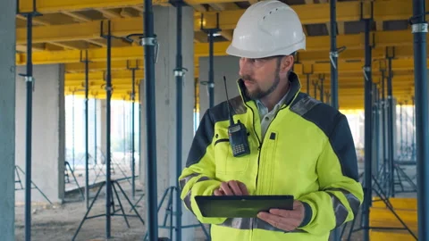 Engineer In Helmets With Tablet Device And Big Paper Drawings Discussing Video stock 113120704