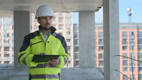 Engineer In Helmets With Tablet Device And Big Paper Drawings Discussing Video stock 113120924