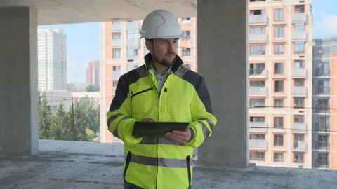 Engineer In Helmets With Tablet Device And Big Paper Drawings Discussing Video stock 113120982