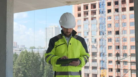 Engineer In Helmets With Tablet Device And Big Paper Drawings Discussing Video stock 113120987