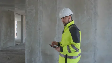 Engineer In Helmets With Tablet Device And Big Paper Drawings Discussing Video stock 113121048