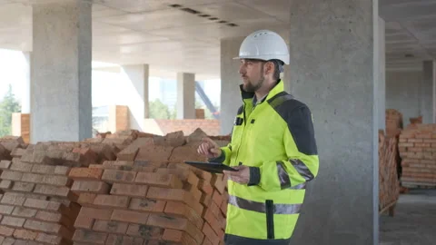 Engineer In Helmets With Tablet Device And Big Paper Drawings Discussing Video stock 113121077