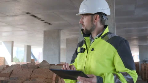 Engineer In Helmets With Tablet Device And Big Paper Drawings Discussing Video stock 113121110