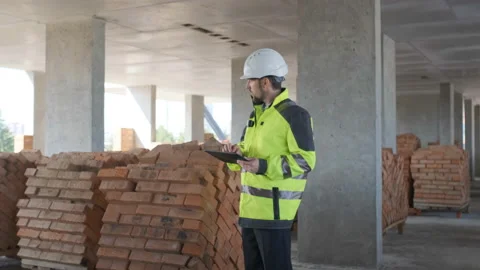 Engineer In Helmets With Tablet Device And Big Paper Drawings Discussing Stock Footage 113121183