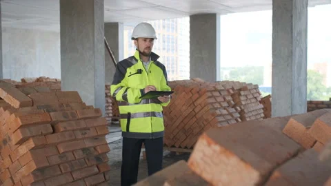Engineer In Helmets With Tablet Device And Big Paper Drawings Discussing Stock Footage 113121221