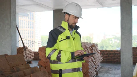 Engineer In Helmets With Tablet Device And Big Paper Drawings Discussing Stock Footage 113121239