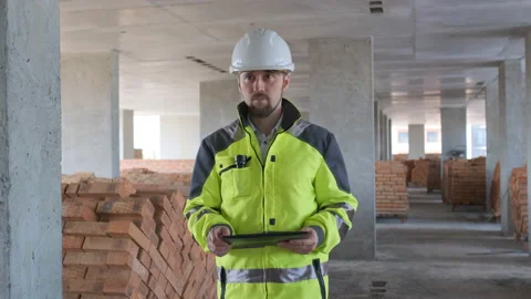 Engineer In Helmets With Tablet Device And Big Paper Drawings Discussing Stock Footage 113121270
