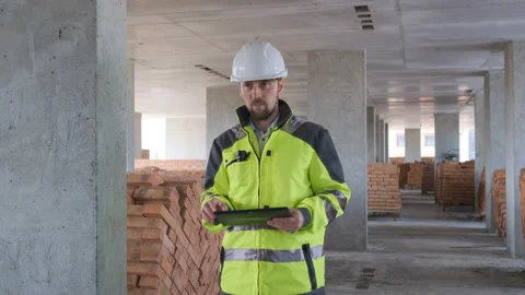 Engineer In Helmets With Tablet Device And Big Paper Drawings Discussing Stock Footage 113121336