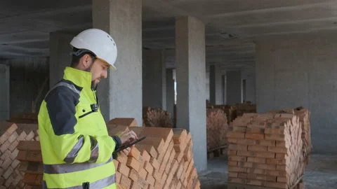 Engineer In Helmets With Tablet Device And Big Paper Drawings Discussing Stock Footage 113121883