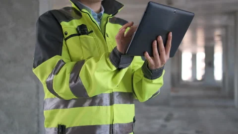 Engineer In Helmets With Tablet Device And Big Paper Drawings Discussing Stock Footage 113348821