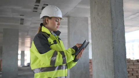 Engineer In Helmets With Tablet Device And Big Paper Drawings Discussing Stock Footage 113348993