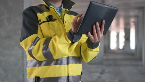 Engineer In Helmets With Tablet Device And Big Paper Drawings Discussing Video stock 114530578