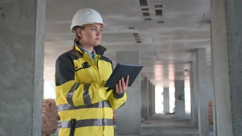 Engineer In Helmets With Tablet Device And Big Paper Drawings Discussing Video stock 114530937