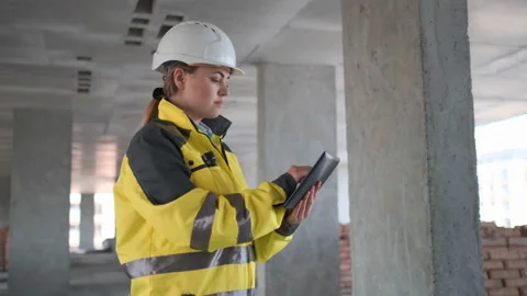 Engineer In Helmets With Tablet Device And Big Paper Drawings Discussing Video stock 114531062