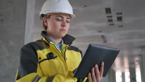 Engineer In Helmets With Tablet Device And Big Paper Drawings Discussing Video stock 114531374