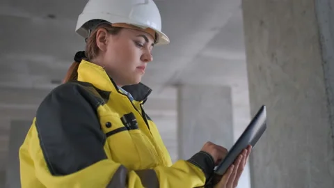 Engineer In Helmets With Tablet Device And Big Paper Drawings Discussing Video stock 114531381