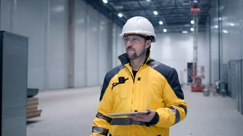Engineer In Helmets With Tablet Device And Big Paper Drawings Discussing Stock Footage 127945998