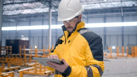Engineer In Helmets With Tablet Device And Big Paper Drawings Discussing Stock Footage 128616538