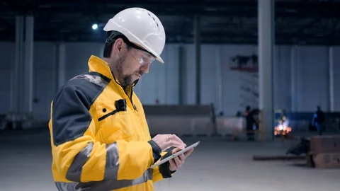 Engineer In Helmets With Tablet Device And Big Paper Drawings Discussing Stock Footage 128616703