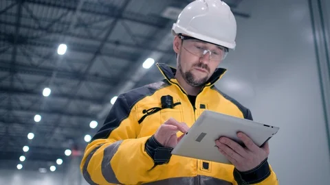 Engineer In Helmets With Tablet Device And Big Paper Drawings Discussing Stock Footage 128616812