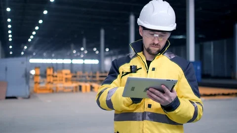 Engineer In Helmets With Tablet Device And Big Paper Drawings Discussing Stock Footage 128616815