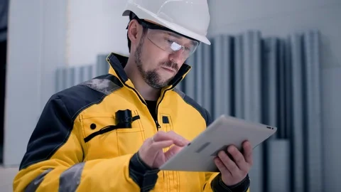 Engineer In Helmets With Tablet Device And Big Paper Drawings Discussing Stock Footage 128635360
