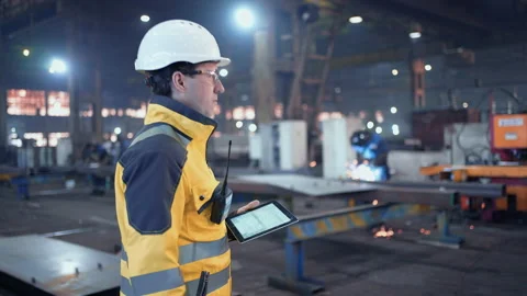 Engineer In Helmets With Tablet Device And Big Paper Drawings Discussing Stock Footage 236887024