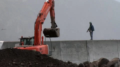 An engineer helping guiding an excavator to drop big stones in construction site Stock Footage 48803546