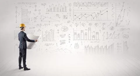 Engineer holding a plan and standing with graphs, charts and reports on the 스톡 사진