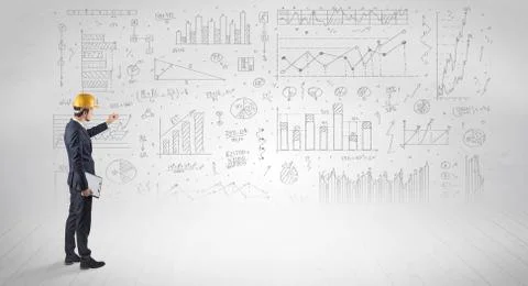 Engineer holding a plan and standing with graphs, charts and reports on the 스톡 사진