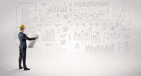 Engineer holding a plan and standing with graphs, charts and reports on the 스톡 사진