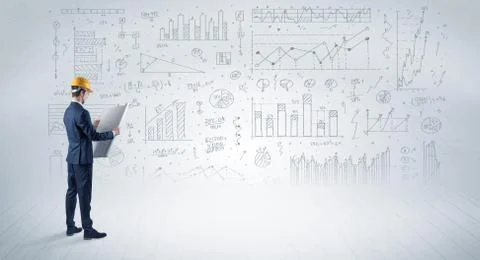Engineer holding a plan and standing with graphs, charts and reports on the 스톡 사진