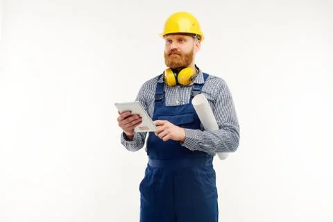 Engineer is holding a tablet in his hands and looking at something Stock Photos