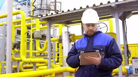 Engineer holding a tablet, talking on walkie-talkie and smiling at camera in Stock Footage 61355985